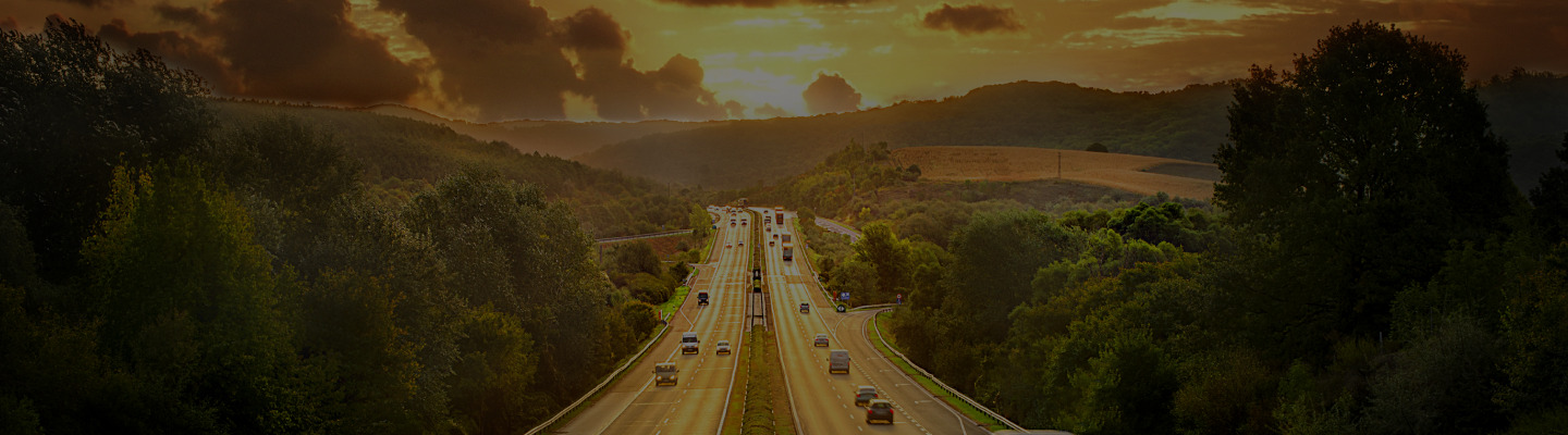 imagem de fundo com carros em uma rodovia no por do sol